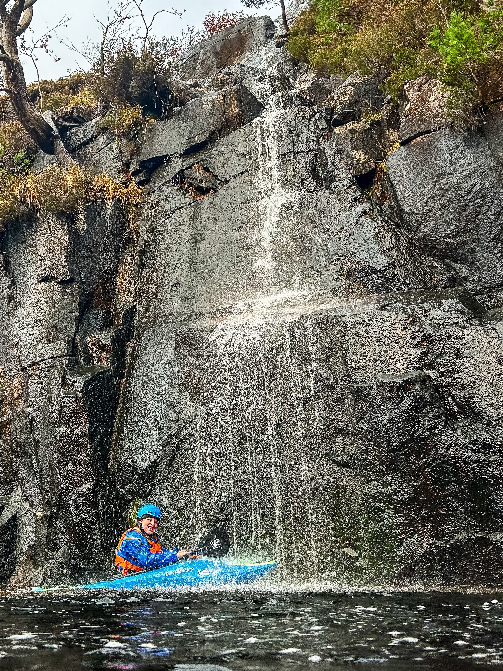 Eva kayaking under waterfall on the River Etive Scotland